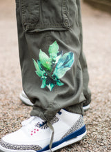 Load image into Gallery viewer, Green roboflower cargos floral graphic closeup with jordan 3s