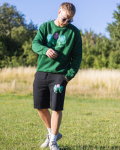 Load image into Gallery viewer, man wearing green oversized misfit painted sweater with black misfit shorts and sunglasses