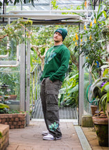 Load image into Gallery viewer, man wearing green oversized roboflower floral graphic cargos with green roboflower sweater, green DFKT logo beanie and jordan 3s