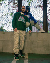 Load image into Gallery viewer, man wearing green roboflower v3 sweater with camo pants