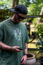 Load image into Gallery viewer, man wearing military green snow white inspired magic mirror graphic t-shirt while looking at his phone