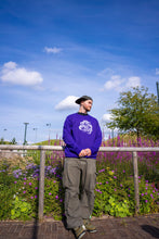Load image into Gallery viewer, man wearing purple DFKT eye bubbles crewneck with oversized roboflower DFKT cargos