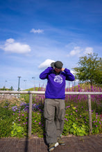 Load image into Gallery viewer, man wearing purple DFKT eye bubbles crewneck with oversized roboflower DFKT cargos while showing chains