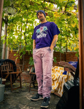 Load image into Gallery viewer, man wearing purple oversized misfit v2 graphic t-shirt with pink tie dye pants and purple DFKT logo beanie