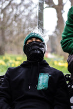 Load image into Gallery viewer, man with balaclava blowing smoke through the mask wearing black fly outside the jar oversized hoodie front graphic