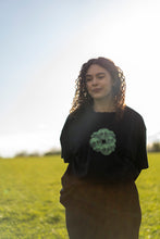 Load image into Gallery viewer, woman wearing an oversized black tree of life t-shirt in a field of grass