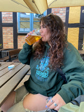Load image into Gallery viewer, woman wearing green oversized mindliquid graphic hoodie with ripped jeans while drinking beer