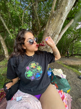Load image into Gallery viewer, woman wearing oversized black rainbow bubbles pride t-shirt while eating grapes