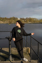 Load image into Gallery viewer, woman wearing tucked in, oversized black tree of life t-shirt with black pants