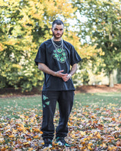 Load image into Gallery viewer, Man wearing an oversized, black Bubbles Tee with oversized Ripped Butterfly Sweatpants