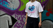 Load image into Gallery viewer, Man wearing white oversized human nature t-shirt with black cargos