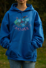 Load image into Gallery viewer, Woman wearing oversized blue Human Nature hoodie