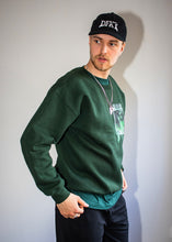 Load image into Gallery viewer, man wearing black DFKT logo dad hat cap with green think outside the jar sweater