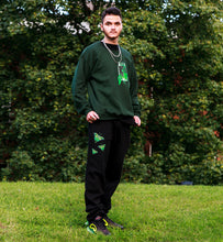 Load image into Gallery viewer, man wearing black ripped butterfly sweatpants and oversized green think outside the jar sweater with nikes