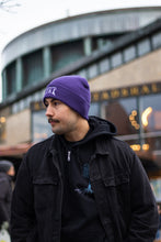 Load image into Gallery viewer, man wearing purple DFKT logo beanie with black denim jacket