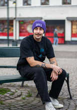 Load image into Gallery viewer, man wearing purple DFKT logo beanie with oversized black roots t-shirt