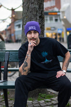 Load image into Gallery viewer, man wearing purple DFKT logo beanie with oversized black roots t-shirt while looking directly into the camera