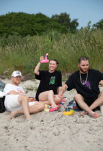 Load image into Gallery viewer, woman wearing black oversized think outside the jar graphic t-shirt with man wearing black euphoria t-shirt at the beach