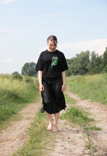 Load image into Gallery viewer, woman wearing black oversized think outside the jar t-shirt with black dress skirt in a field