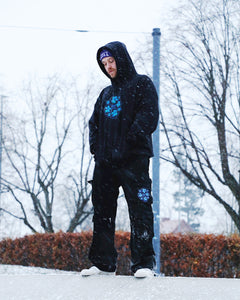 Man wearing oversized Bubbles Hoodie and Oversized black Bubbles Cargos In the snow