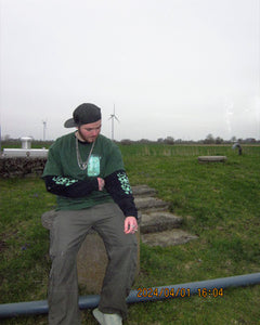 Model wearing Black oversized Growth Longsleeve and green Fly Outside The Jar graphic t-shirt