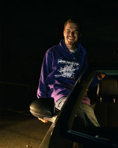 man smiling wearing purple oversized onecolor graphic hoodie