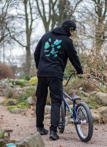 man wearing black fly outside the jar butterfly graphic hoodie with black cargos