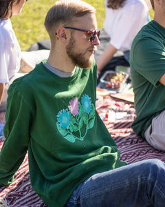 man wearing green misfit painted sweater and sunglasses at picnic