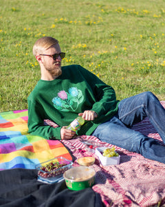 man wearing green misfit painted sweater at picnic