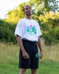 man wearing oversized white misfit painted t-shirt in grass field