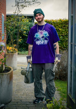 Load image into Gallery viewer, man wearing purple oversized misfit v2 graphic t-shirt with green roboflower cargos and green DFKT logo beanie and puma rs-x 