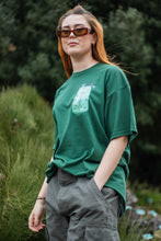 Load image into Gallery viewer, woman rocking green oversized fly outside the jar t-shirt with shades