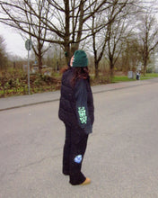 Load image into Gallery viewer, woman wearing a black growth longsleeve t-shirt with black bubbles cargos and black vest