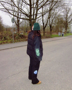woman wearing a black growth longsleeve t-shirt with black bubbles cargos and black vest