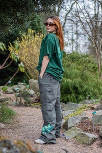 woman wearing green oversized roboflower cargos with oversized green fly outside the jar t-shirt