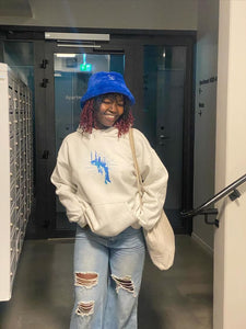 woman wearing oversized white euphoria graphic hoodies with blue jeans