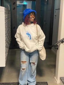 woman wearing oversized white euphoria graphic hoodies with blue jeans