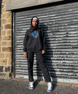 Woman wearing Black Bubbles Hoodie with black jeans and Blue shoes