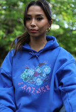 Load image into Gallery viewer, Woman wearing oversized blue Human Nature graphic hoodie 