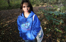 Load image into Gallery viewer, Woman wearing oversized blue Human Nature hoodie with a human nature tote bag