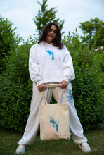 Load image into Gallery viewer, Woman wearing oversized white Euphoria Hoodie with Euphoria Graphic Tote Bag 
