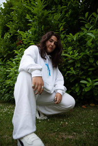 Woman wearing oversized white Euphoria Hoodie with all white outfit