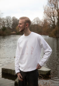 man wearing white oversized thinker graphic sweater and smiling big