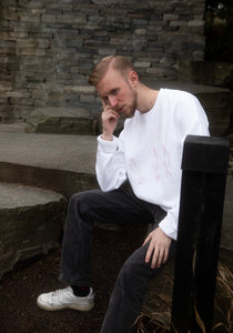 man wearing white oversized thinker sweater with black jeans