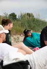 Load image into Gallery viewer, woman wearing oversized green no luck t-shirt and a woman wearing black think outside the jar t-shirt at the beach